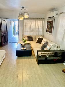 圣多明各Casa con Parqueo Privado, Patio y Jacuzzi.的客厅配有沙发和桌子