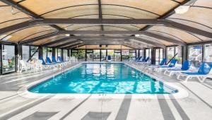 纽波特惠灵顿度假酒店的一个带蓝色椅子和大型天花板的游泳池