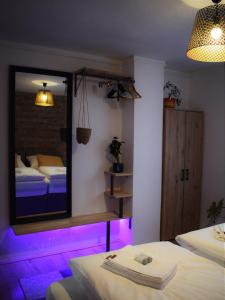 萨格勒布Green Garden Station的客房设有两张床和一面带紫色灯的镜子。