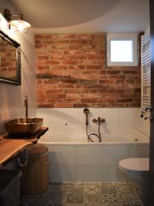 萨格勒布Green Garden Station的一间带砖墙和浴缸的浴室