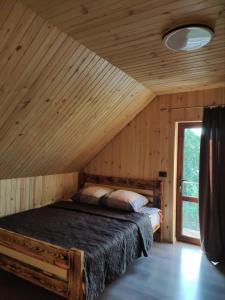 斯维季亚济Садиба ЯНА的配有窗户的小木屋内的一张床位