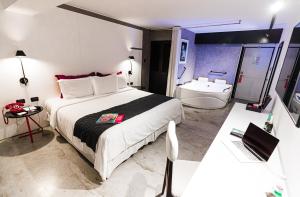 利马BTH Hotel – Boutique Concept的一间卧室配有一张床,浴室设有浴缸