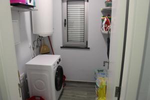 BiscoitosPedras Negras House的带窗户的客房内的洗衣机