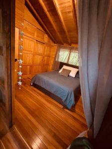 瓜尔内Beehouse Arví Cabaña的小屋内的小卧室,配有床铺