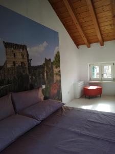 明乔河畔的瓦雷奇奥Una Rosa sul Mincio的卧室配有一张床,墙上挂有绘画作品