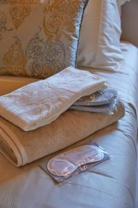 圣马力诺One Suite的床上有毛巾和盘子的床