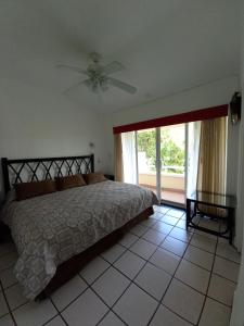 曼萨尼约Villas del Palmar Manzanillo with Beach Club的一间卧室配有一张床和吊扇