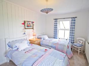 HilgayGreenbank Cottage的一间卧室设有两张床和窗户。