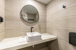 济州市Ventimo Hotel & Residence Jeju的一间带水槽和镜子的浴室