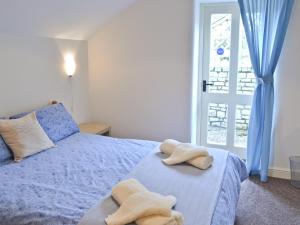 West PennardThe Old Stable的一间卧室配有蓝色的床和毛巾