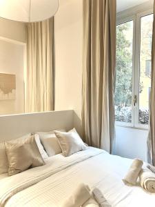 米兰Divini Gae Aulenti的卧室配有一张大白色床和窗户