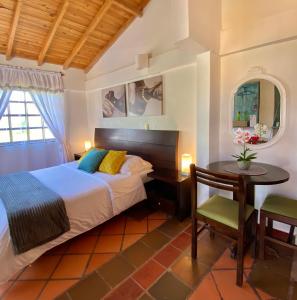 莱瓦镇Hotel Evoque Sáchica的一间卧室配有一张床、一张桌子和一张桌子