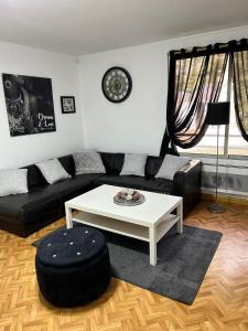 图卢兹Chez mimi的客厅配有黑色沙发和白色咖啡桌