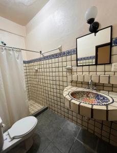 埃斯孔迪多港Hotel Rancho Escondito的浴室配有盥洗盆、卫生间和浴缸。