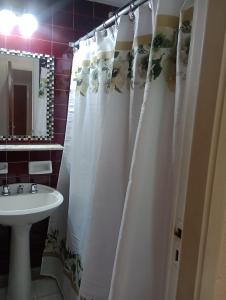 米拉玛Hotel Neptuno的浴室设有白色的淋浴帘和水槽