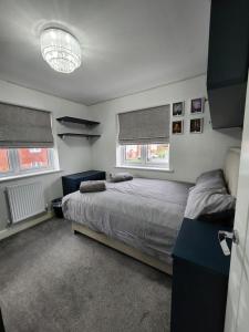 KentSpacious 3-bed Luxury Maidstone Kent Home - Wi-Fi & Parking的一间卧室设有一张床和两个窗户。