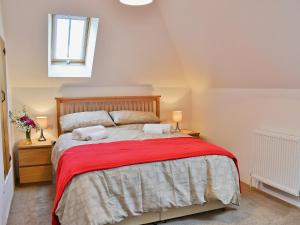 FletchingRomany的一间卧室配有一张带红色毯子的大床