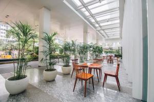 雅加达JS鲁旺萨会议中心酒店的配有桌椅和盆栽的植物的房间