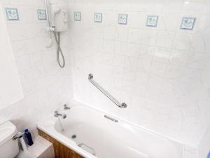 Foxham斯特普乡村别墅的白色的浴室设有浴缸和卫生间。