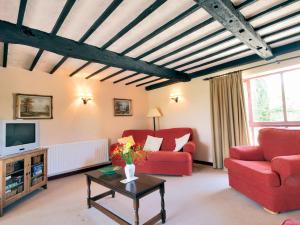 奇平索德伯里Fox Cottage - E4510的客厅配有红色椅子和电视