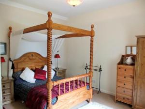 ArnisdaleBrightwater Cottage的一间卧室配有一张木床和木架