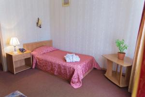 阿特劳Laetu的一间小卧室,配有粉红色的床和两张桌子
