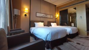 天津天津梅江中心皇冠假日酒店的酒店客房,设有两张床和镜子