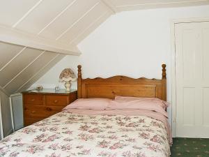 罗宾胡兹贝弗拉格斯塔夫乡村别墅的一间卧室配有一张带花卉床罩和梳妆台的床。