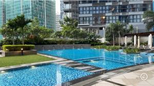 马尼拉Uptown BGC Luxury 1br Suite with Fast Wifi的一座高楼建筑中的大型游泳池