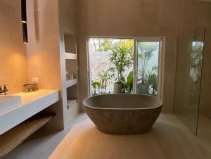 麦夸里港Tallowwood House Luxury Bed & Breakfast的带窗户的浴室设有大浴缸