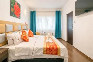 利马Manantial Hostal No.004的卧室配有一张带彩色枕头的大型白色床。