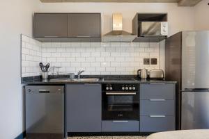 布鲁堡史特兰Manhattan On Coral Apartments的厨房配有不锈钢用具和灰色橱柜