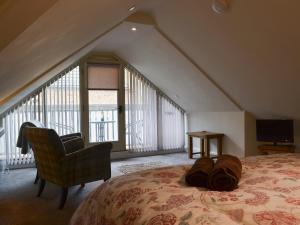 亨斯坦顿The Hayloft的卧室配有床、椅子和窗户。