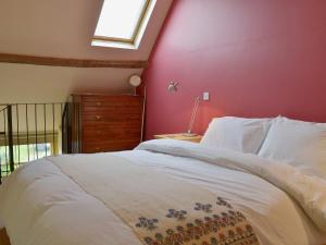 Wookey小布尔科特度假屋的卧室配有白色的床铺和红色的墙壁