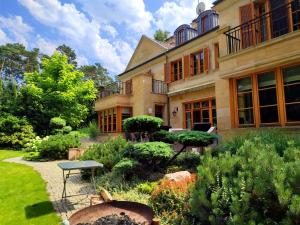 MagdalenkaStately Home in Magdalenka, nr Warsaw的前面有花园的房子