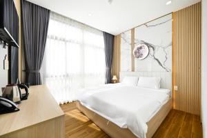 胡志明市Lotus Airport Hotel Saigon的卧室设有一张白色大床和一扇窗户。