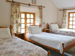 帕特代尔Brothersfield Cottage的一间卧室设有两张床和两个窗户。