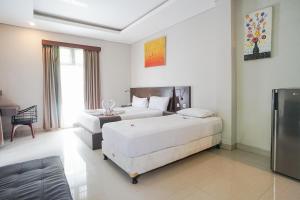 沙努尔阿卡萨特兰西特酒店的酒店客房,设有两张床和一张沙发
