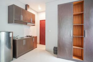 沙努尔阿卡萨特兰西特酒店的厨房配有木制橱柜和不锈钢冰箱。