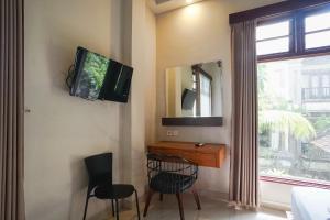 沙努尔阿卡萨特兰西特酒店的配有电视和桌椅的房间