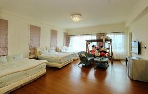 Dahan花莲七星潭海湾民宿的大型客厅设有两张床和一张桌子