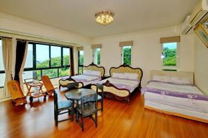 Dahan花莲七星潭海湾民宿的一间卧室配有两张床和一张桌子及椅子
