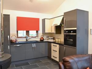 StrachanCairn View的厨房配有灰色橱柜和红色窗帘