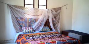 努瓦克肖特Auberge Triskell的一间卧室配有一张带蚊帐的床