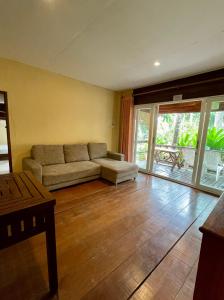 象岛棕榈树天堂度假酒店的带沙发和滑动玻璃门的客厅