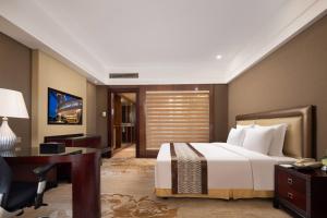宝安深圳宝利来国际大酒店(宝安,福永)的酒店客房配有一张床、一张书桌和一张书桌。