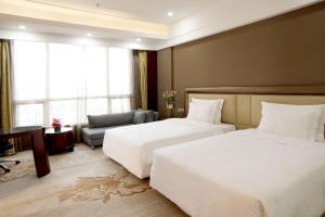 宝安深圳宝利来国际大酒店(宝安,福永)的酒店客房,设有两张床和一张沙发