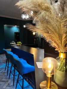 布达佩斯Hotel Rumor的一间酒吧,里面设有蓝色的凳子和一张带台灯的桌子