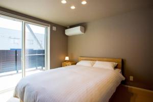 松江市Rakuten STAY HOUSE x WILL STYLE Matsue 101的一间卧室设有一张大床和一个大窗户