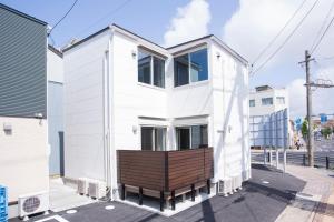 松江市Rakuten STAY HOUSE x WILL STYLE Matsue 101的街上有长凳的白色房子